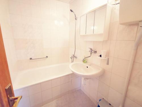 a white bathroom with a sink and a bath tub at Penzion Ráj in Blíževedly