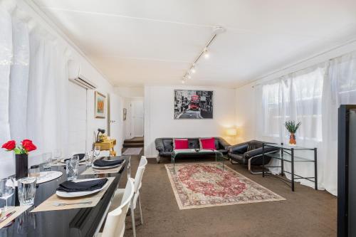 a living room with a table and a couch at Cozy 2Bed& 1Bath Guest Suite surrounded by garden near Lake with Free parking and Wi-Fi in Yarralumla