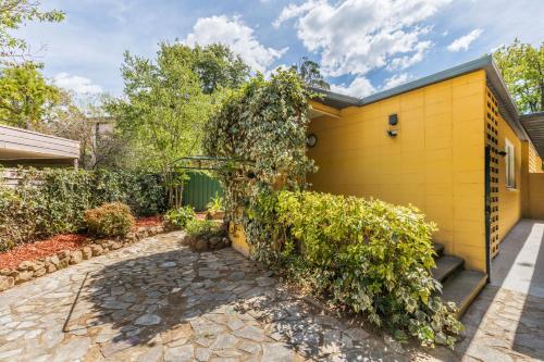 a yellow house with a yellow wall at Cozy 2Bed& 1Bath Guest Suite surrounded by garden near Lake with Free parking and Wi-Fi in Yarralumla
