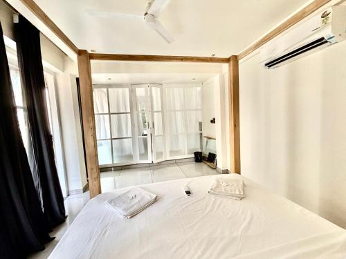 a white bed in a room with a large window at Baga Beach Sea Salacia in Goa