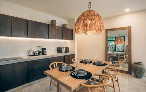 a kitchen and dining room with a wooden table and chairs at Luxury Jungle Villa-Pvt Pool -100mbs- Concierge 8A in Tulum