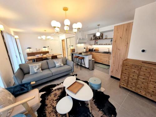 un salon avec un canapé et une table dans l'établissement Les Gets - Appartement moderne avec grande terrasse, parking et 2 chambres - FR-1-598-185, aux Gets
