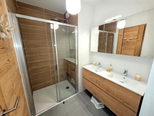 une salle de bain avec douche et lavabo dans l'établissement Les Gets - Appartement moderne avec grande terrasse, parking et 2 chambres - FR-1-598-185, aux Gets