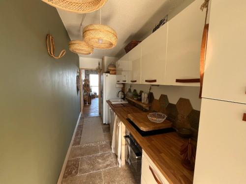 une cuisine avec des armoires blanches et un comptoir dans l'établissement Arcachon - Appartement T3 avec Terrasse, Vue Mer et Parking - FR-1-319-593, à Arcachon