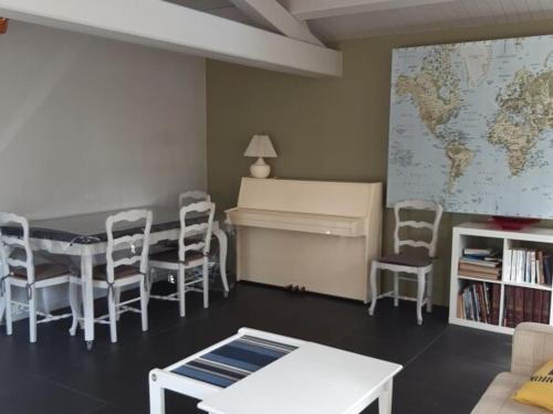 Cette chambre comprend un bureau, une table et des chaises. dans l'établissement Maison confortable 5 pers - Forêt & plage à 500m - Animaux admis - FR-1-823-139, à Barbâtre
