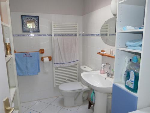 une salle de bain blanche avec des toilettes et un lavabo dans l'établissement Maison confortable 5 pers - Forêt & plage à 500m - Animaux admis - FR-1-823-139, à Barbâtre