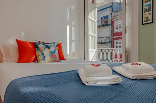 a bed with towels sitting on top of it at Antero Quental Residence in Porto