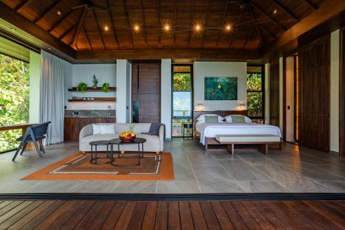 a living room with two beds and a table at Rancho Pacifico - Boutique Hotel for Adults in Uvita