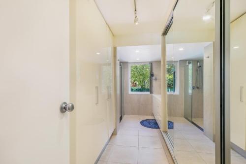 bagno con cabina doccia e porta in vetro di Charming Garden Guest Suite in Leafy Yarralumla a Yarralumla