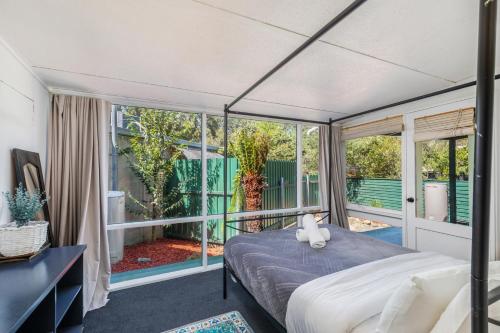 a bedroom with a bed and a balcony at Charming Garden Guest Suite in Leafy Yarralumla in Yarralumla