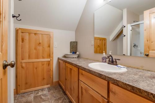 a bathroom with a sink and a mirror at `Antler Ridge` Hot tub, Wifi, BBQ, River Access! in Packwood