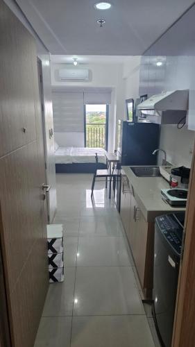 a small room with a kitchen and a bed at Smdc green 2 residence in Pasong Bayog