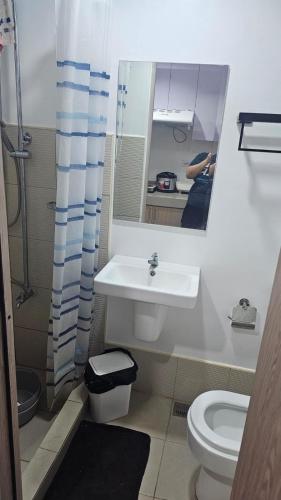 a bathroom with a sink and a toilet and a mirror at Smdc green 2 residence in Pasong Bayog
