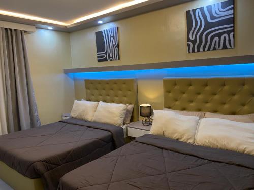 a bedroom with two beds and a head board at GBF Premium Suite-Rm 207 Twin Hearts Residences 1 in Roxas City