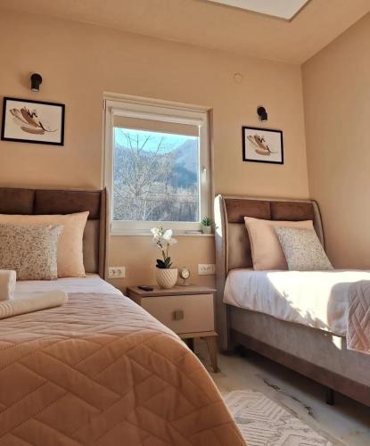 a bedroom with two beds and a window at "Vista Paradiso" - Jaz - lake view in Višegrad