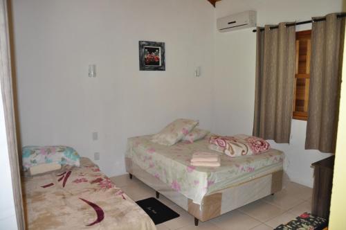 Habitación con 2 camas y espejo. en Pousada Heritage Colonial, en Nova Petrópolis