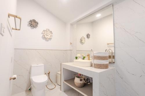 a white bathroom with a toilet and a sink at Rocka Villa Maenam in Amphoe Koh Samui