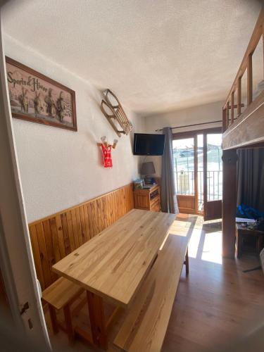 - une table en bois dans le salon avec une télévision dans l'établissement Appartement Cosy Tout Confort, aux Angles