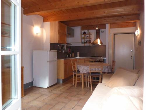 a small kitchen with a table and a white refrigerator at B&B Ploncher in Chiavenna