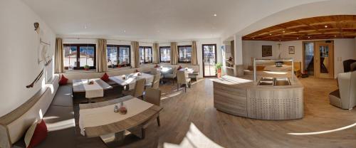a restaurant with tables and chairs in a room at Haus Morgensonne in Sankt Anton am Arlberg