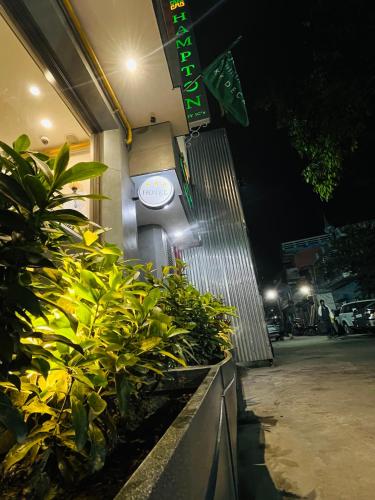 a sign on the side of a building with plants at Hampton By IC's in Noida