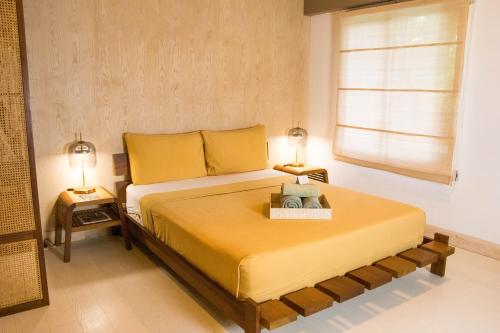 a bedroom with a large bed with two lamps at Asmara Urban Resort & Lifestyle Village Powered by ASTON in Cebu City