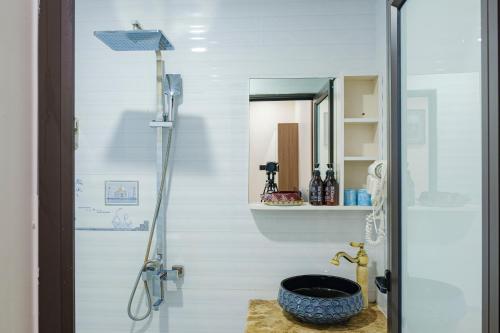 a bathroom with a shower with a large blue bowl at Roza Luxury Hotel Cat Ba - Pool & Rooftop in Cat Ba