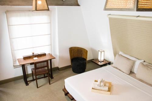 a bedroom with a bed and a table and a window at Asmara Urban Resort & Lifestyle Village Powered by ASTON in Cebu City