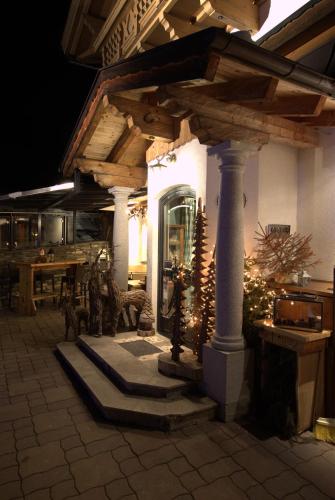 a porch of a house at night with a christmas tree at Hotel und Alpen Apartments mit Sauna - Bürglhöh in Bischofshofen