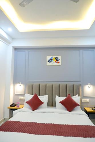 a bedroom with a large bed with red pillows at Hotel Mavens House Artemis Hospital Road in Gurgaon