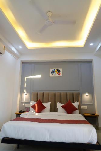 a bedroom with a large bed with red pillows at Hotel Mavens House Artemis Hospital Road in Gurgaon