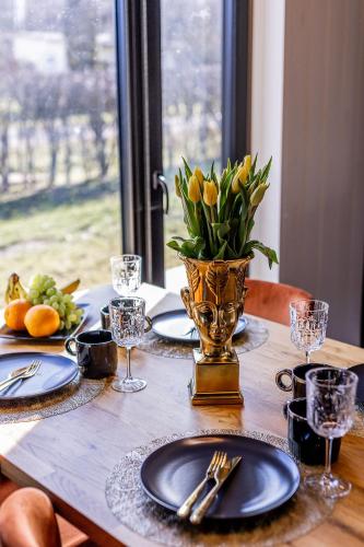 a wooden table with a vase of flowers on it at Hubane suvemaja Võhandu jõe lähistel in Võru