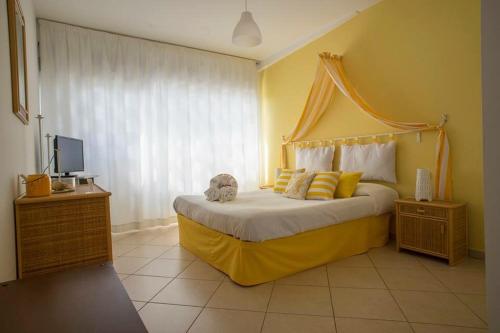 a bedroom with a large bed with a yellow headboard at L'Approdo in San Leone