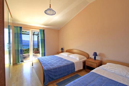 two beds in a bedroom with a view of the ocean at Apartments Đuričić in Lovište