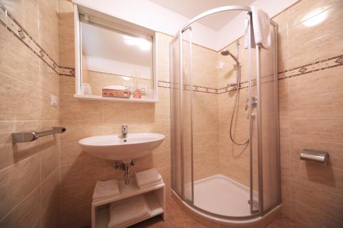 ein Bad mit einer Dusche und einem Waschbecken in der Unterkunft Villa Otto in St. Christina in Gröden