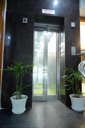 an elevator door with two potted plants in front of it at Hotel Mavens House Artemis Hospital Road in Gurgaon