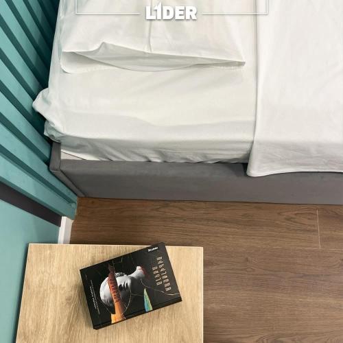a book sitting on a table next to a bed at Hotel Lider Complex in Vaykʼ