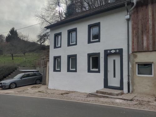 a car parked in front of a white house at 4 persons wohnung in de Eifel in Baustert