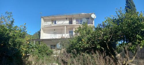 a white building on the side of a hill with trees at Blue Lagoon Apartment Silver in Lovište