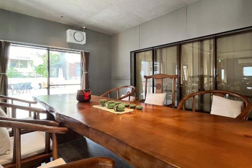 a dining room with a wooden table and chairs at Guesthouse Hakone Lumi in Hakone