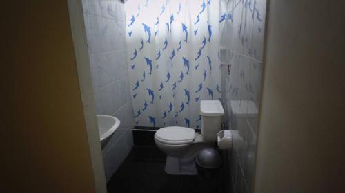 baño con aseo y papel pintado de pescado azul en Indiana Lodge, en Mazán