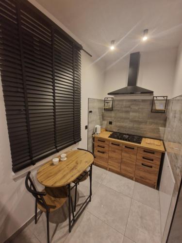 a kitchen with a wooden table and a stove at Apartament Zacisze 2 in Przemyśl
