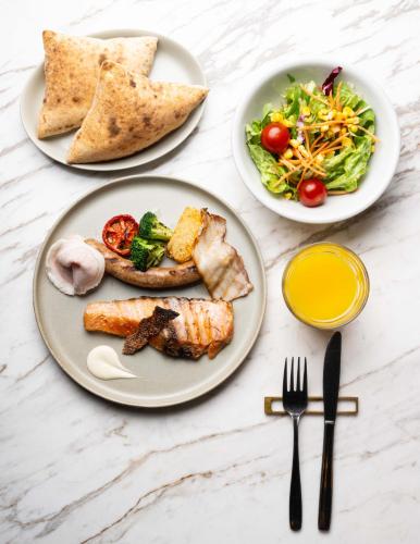 a table with three plates of food and a salad at NOHGA HOTEL AKIHABARA TOKYO in Tokyo