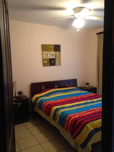 a bedroom with a bed with a colorful striped blanket at CocoMarindo in Coco