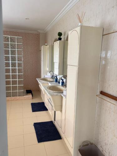 a white bathroom with two sinks and a refrigerator at Amaca in Mijas Costa