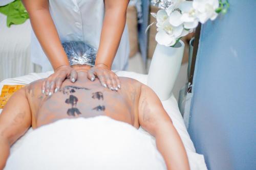 a bride and groom are holding their hands on the back of a man at Nefaland Hotel in Dar es Salaam