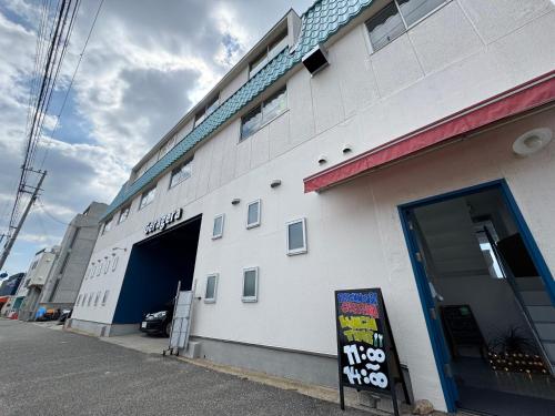 a white building with a sign in front of it at BeachHouse Geragera in Kobe