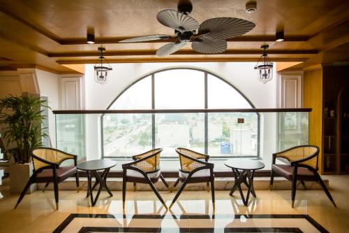 a dining room with a table and chairs and a ceiling fan at Nam Khánh HOTEL in Vĩnh Tuy