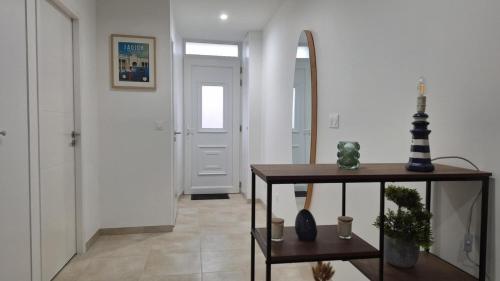 a hallway with a table and a mirror at L'évasion in Saujon