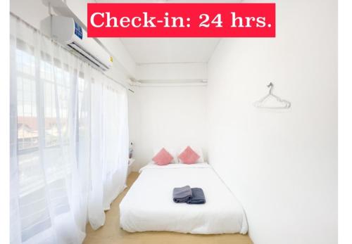 a bedroom with a bed and a sign that reads check in hrs at TRANSIT Donmueang Airport HOSTEL in Thung Si Kan